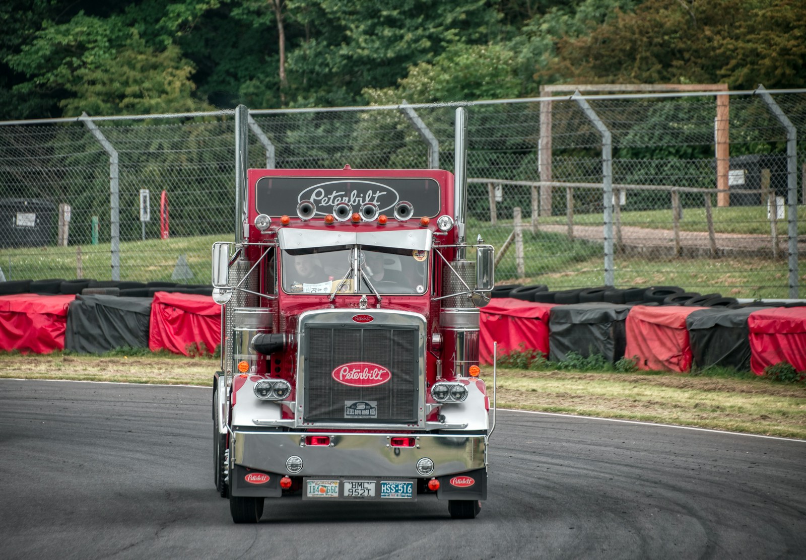 a red semi truck driving down a race track